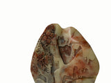 A carved stone plaque featuring a detailed landscape design with trees, mountains, and dripping water motifs, crafted from beige and brown marbled stone.