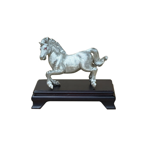 Decorative horse figurine on a black stand against a white background